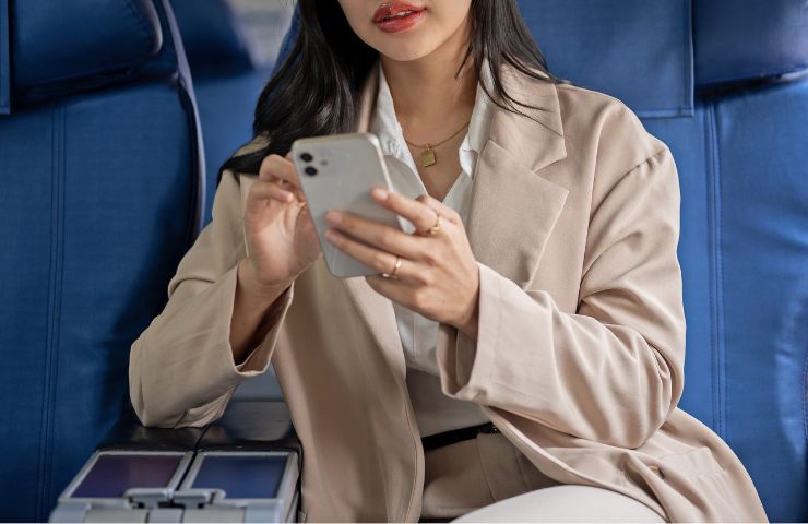 Donna usa cellulare in aereo