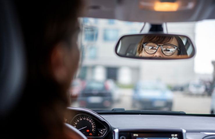 Donna con occhiali alla guida dell'auto