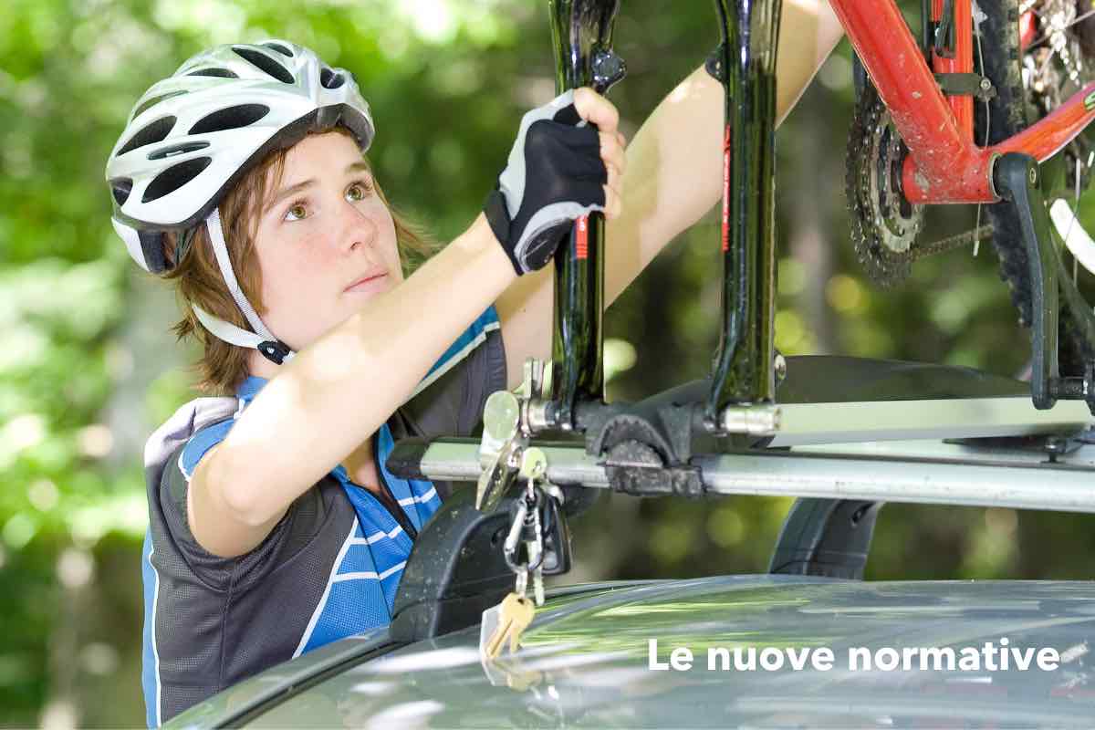 Ragazza blocca la bicicletta sul portabici dell’auto